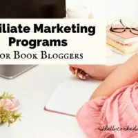 Book Affiliate Programs For Book Bloggers Blog Post Cover with woman in pink shirt sitting at a computer with a stack of pink books and pen and notebook open