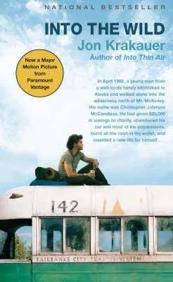 Into the Wild by Jon Krakauer book cover with young brunette man sitting on top of an old school bus