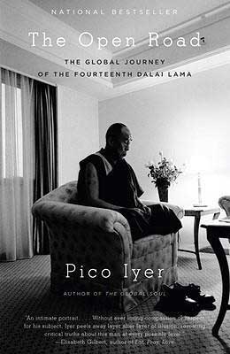 The Open Road by Pico Iyer book cover with monk sitting in a chair in the middle of the room