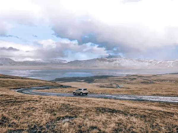 Silver car driving on road in Iceland in winter