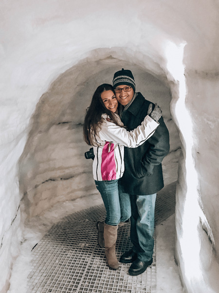 7 Day Iceland Itinerary Perlan Ice cave with brunette man and woman standing in simulated ice cave wearing winter coats at the Perlan in Reykjavik