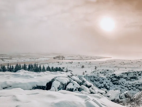 Þingvellir National Park Iceland with snow and sun behind clouds