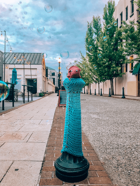 Moving to downtown Asheville North Carolina with lamppost covered with knit pig and bubbles floating in the air