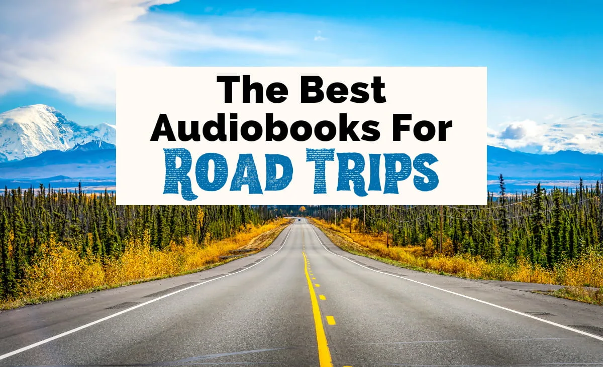 Best Audiobooks For Road Trips featured image with pavement road with yellow lines surrounded by green trees and bushes with blue mountains and clouds in background