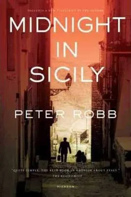 Midnight In Sicily by Peter Robb book cover with orange sky and man walking down a narrow street in the shadows