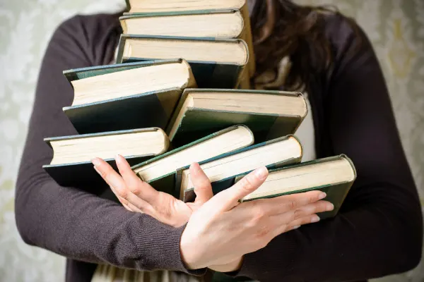 Book Blog Post Book Hauls with person holding an uneven stack of books