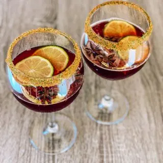 Cheerwine Cocktail bourbon with two large wine glasses filled with Cheerwine and lime garnish
