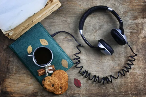 Controversial Book Blog Post Ideas Audiobooks with black headphones attached to a green book