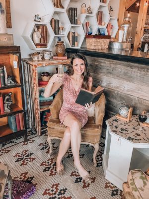 Meet Christine The Uncorked Librarian white brunette female in a pink dress holding a book and glass of champagne