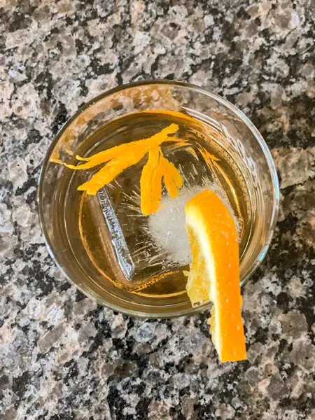 Orange Old Fashioned Mead Cocktail with shot from top of glass with square ice cube and orange zest and slice garnish