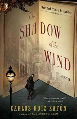 The Shadow of the Wind by Carlos Ruiz Zafón book cover with street lamp and person walking stealthily away with buildings in background