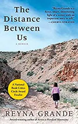 The Distance Between Us by Reyna Grande book cover with rocky hills and person in pink shirt walking away