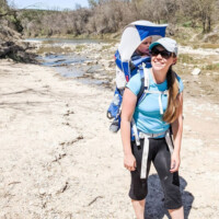 Tori Curran Explore with Tori white, blonde woman hiking with backpack and young child on back in carrier