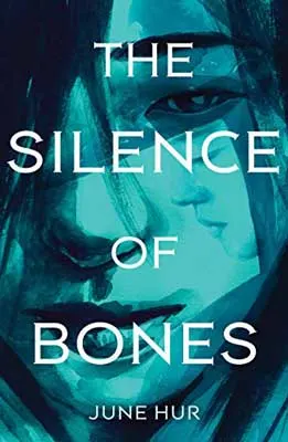 The Silence of Bones by June Hur book cover with person's face up close with blue-green tiny