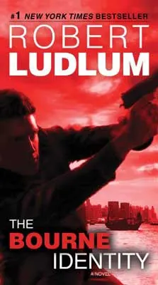 The Bourne Identity by Robert Ludlum book cover with red background and man holding an aimed gun
