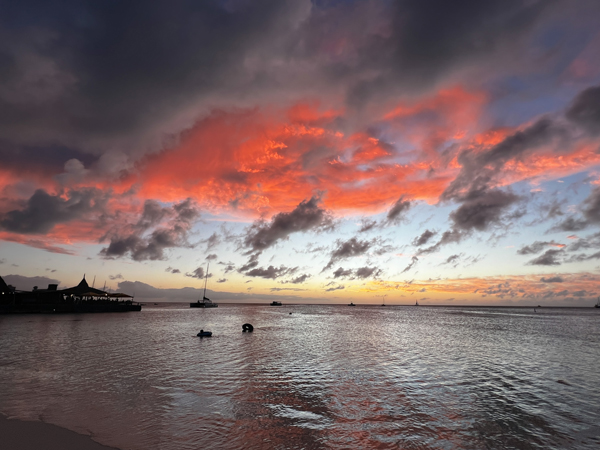 Aruba sunset on Palm Beach with pink and purple cloudy sky over beach