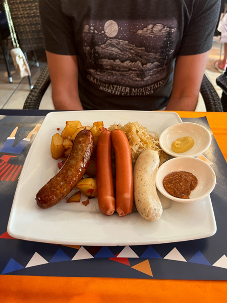 Bavaria German Restaurant in Aruba with meats and sausages, white, brown, and orange with fried potatoes and mustard condiments