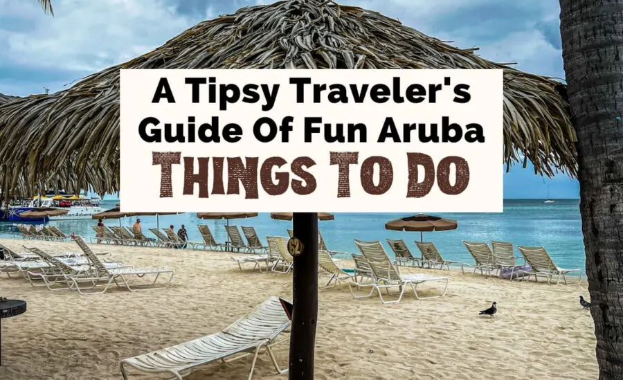 A tipsy traveler's guide of things to do in Aruba with image of Palm Beach with sun umbrellas and beach lounge chairs 