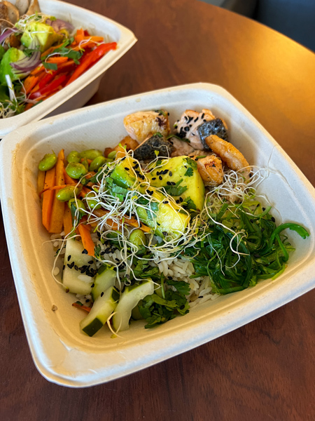 Garden Fresh Cafe in Aruba takeout with seared salmon, white rice, cucumbers and carrot slices in a bowl