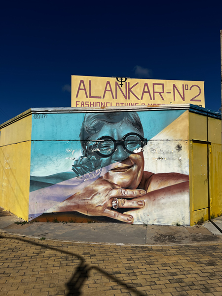 Street Art in San Nicolas Aruba with blue and yellow portrait mural of Elton John with iconic thick glasses
