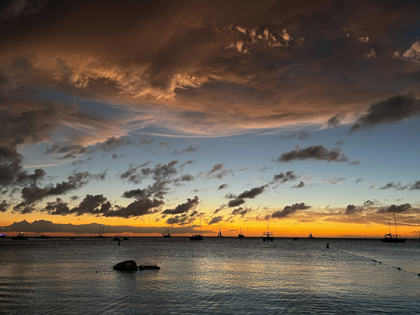 Sunset Over Palm Beach Aruba with orange and blue sky with pink tinted clouds