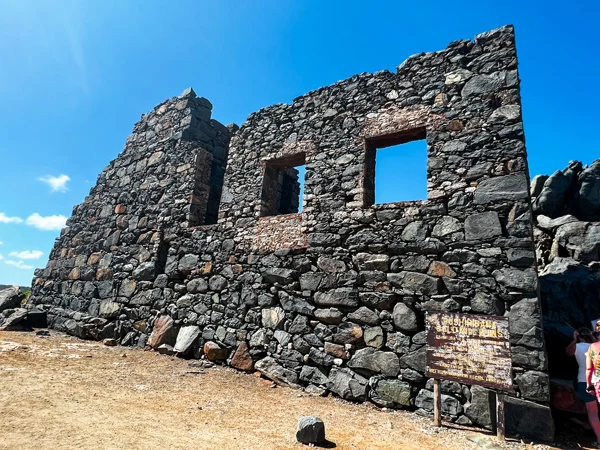 Bushiribana Gold Mill Ruins in Aruba with crumbling stone facade of building with cut outs for windows